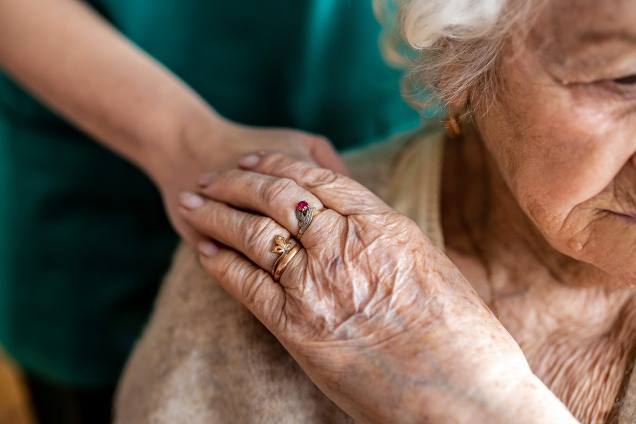 Cropped shot of a senior woman holding hands with a nurse